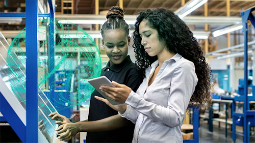 Due donne in un magazzino che controllano i dati su un tablet